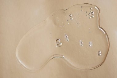 Gümüş metalik arka planda sıvı şeffaf jel örneği. Kabarcıklı yapı, kozmetik afiş..
