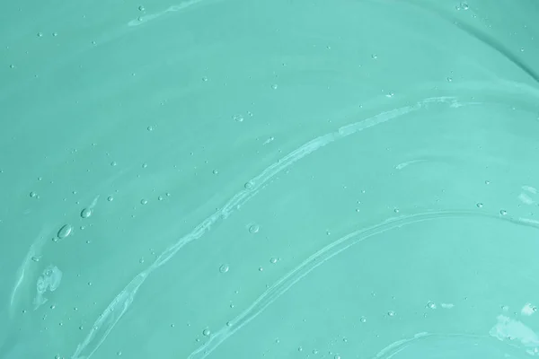 Mavi arka planda köpüklü jöle salladı. Kozmetik aromalı aloe vera ya da antibakteriyel jel sürmüş. Kopya alanı kadar iyi..