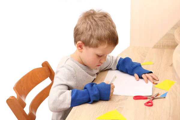 Netter Junge Vorschulalter Sitzt Tisch Und Schreibt Auf Papierbögen Bildungskonzept — Stockfoto