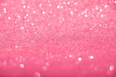 Parlak bokeh ile odaklanmış pembe parıltılı arkaplan.