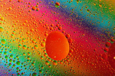 Su yüzeyine yağ damlalarının makro görüntüsü. Kozmik daireler molekül yapısına benziyor. Fotokopi alanı ile arka plan, şablon kadar iyi..