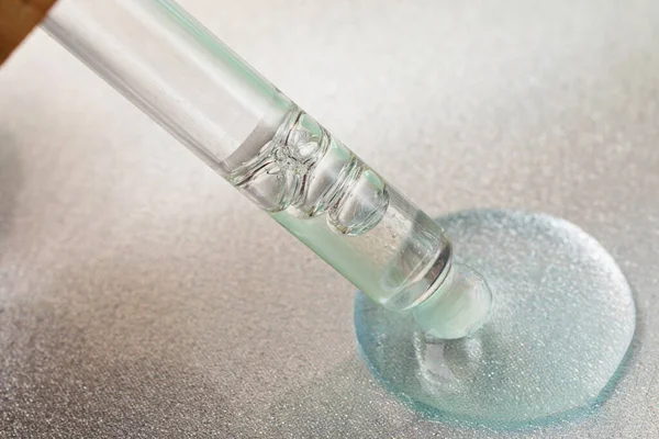 Macro photography of the glass pipette in the liquid cosmetic gel. — Stock Photo, Image