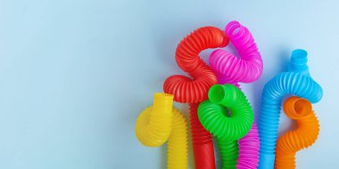 Çok renkli pop tüplerinin üst görüntüsü. Çocuklar için moda anti-stres oyuncağı. Kopya alanı olan pankart..