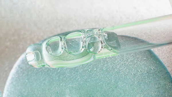 Macro photography of glass pipette in liquid cosmetic gel. — Stock Photo, Image