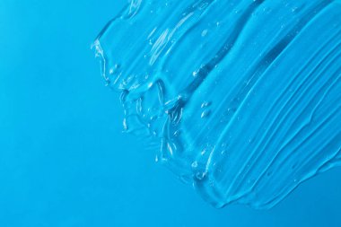 Mavi arkaplanda kozmetik desenli jel. Metin ve model konsepti için alanı kopyala.