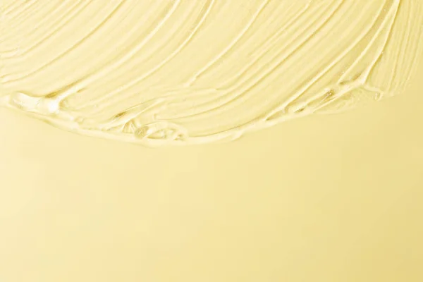 Pastel sarı arka planda kozmetik desenli jel. Metin ve model konsepti için alanı kopyala.