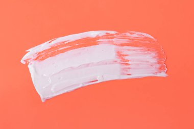 Turuncu arka planda soyut beyaz kozmetik krem lekesi, soyut form.