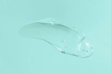 Mavi arkaplanda şeffaf kozmetik jel kokusu. Metin ve model konsepti için alanı kopyala.