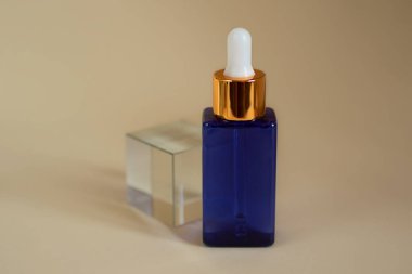 Mavi kozmetik şişeleri, cam podyumda duruyor..