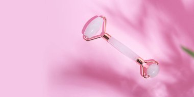 Pembe kuvarstan yüz silindiri, makyaj konsepti, kopyalama alanı olan büyük afiş.