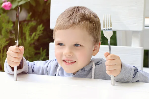 Smiling Child Shows Wants Eat Kid Holding Fork Knife Table — Stockfoto