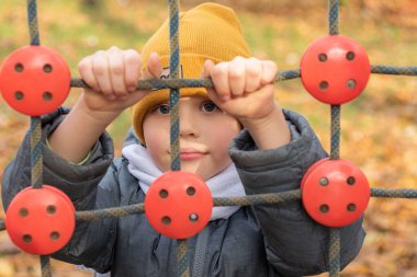 İp merdivene tırmanan oğlanın yakın çekimi..