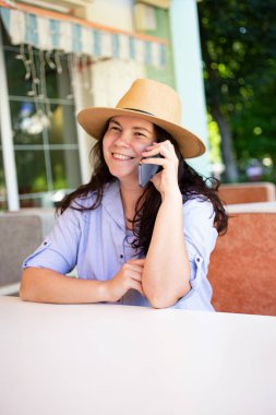 Happy stylish woman outside,making call via smartphone.Vertical photography.
