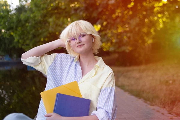 Student girl with folders outdoor.Copy space for text,back to school,college,sunlight on background.