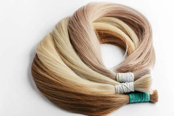 Curved hair samples for extension rolled up,different colors.White background.