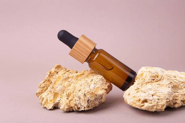 Eco friendly oil dropper with wooden cover on the natural stones.Good as cosmetics mockup.