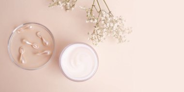 Üzerinde beyaz krema ve kozmetik kapsülleri bulunan açık kutunun en üst görüntüsü. Pastel renkler, maket gibi, büyük pankart gibi..