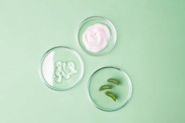 Üstünde kozmetik jel ve aloe vera dilimleri olan petri kaplarının fotoğrafları. Organik kozmetik konsepti..