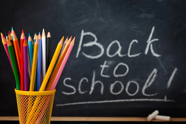 School supplies against blackboard. — Stock Photo, Image