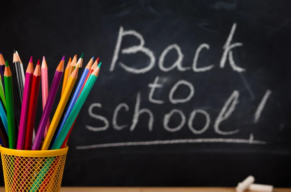 School supplies against blackboard. — Stock Photo, Image