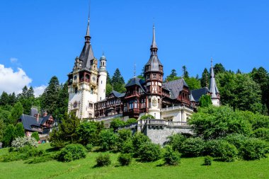 Romanya 'nın Sinaia kentinde güneşli bir yaz gününde Bucegi Dağları (Muntii Bucegi) yakınlarındaki Peles Kalesi' nin (Castelul Peles) güzel neo-rönesans binası