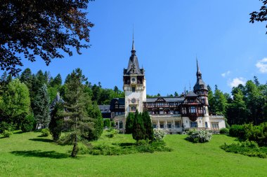 Romanya 'nın Sinaia kentinde güneşli bir yaz gününde Bucegi Dağları (Muntii Bucegi) yakınlarındaki Peles Kalesi' nin (Castelul Peles) güzel neo-rönesans binası