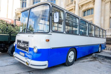 Bükreş, Romanya, 2 Ekim 2021: 1972 yılında üretilen ve güneşli bir sonbahar gününde klasik araba koleksiyonları için düzenlenen bir etkinlikte sokağa park edilen eski canlı mavi-beyaz Roma dizel dizel 111 klasik otobüsü