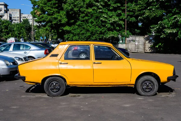 Bükreş, Romanya - 5 Haziran 2021: Eski, canlı, turuncu Rumen Dacia 1300 klasik araba güneşli bir yaz gününde caddeye park etti