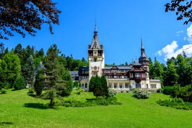 Romanya 'nın Sinaia kentinde güneşli bir yaz gününde Bucegi Dağları (Muntii Bucegi) yakınlarındaki Peles Kalesi' nin (Castelul Peles) güzel neo-rönesans binası