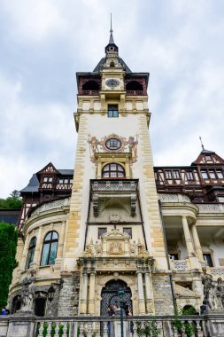 Romanya 'nın Sinaia kentinde bulutlu bir yaz gününde Bucegi Dağları (Muntii Bucegi) yakınlarındaki Peles Kalesi' nin (Castelul Peles) güzel neo-rönesans binası