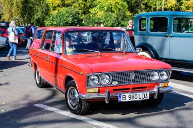 Bükreş, Romanya, 24 Ekim 2021: Güneşli bir sonbahar gününde, klasik araba koleksiyonu etkinliğinde caddede kırmızı bir Lada vintage araba trafikte