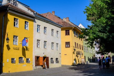 Sighisoara, Romanya, 13 Temmuz 2021: Güneşli bir yaz gününde Transilvanya 'nın Sighisoara Kalesi' nin tarihi merkezinde eski renkli evler
