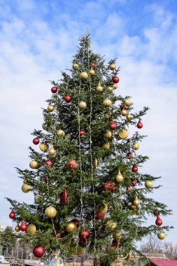 Güneşli bir sonbahar gününde Moghioros olarak bilinen Davul Taberei Parkı 'ndaki (Parcul Drumul Taberei) Noel Pazarı' nda büyük süslü yeşil ağaç.