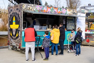 Bükreş, Romanya - 28 Kasım 2021: Güneşli bir günde, Davul Taberei Parkı 'nda (Parcul Drumul Taberei) geleneksel içki, yiyecek ve tatlılarla dolu renkli bir minibüs.