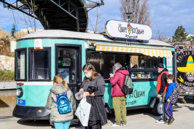 Bükreş, Romanya - 28 Kasım 2021: Güneşli bir günde, Davul Taberei Parkı 'nda (Parcul Drumul Taberei) geleneksel içki, yiyecek ve tatlılarla dolu renkli bir minibüs.