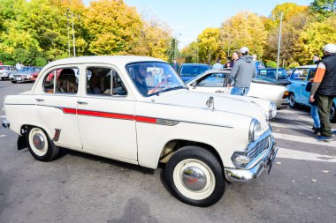 Bükreş, Romanya, 24 Ekim 2021: Canlı beyaz Moskvitch 403 Rus klasik arabası güneşli bir sonbahar gününde şehir merkezindeki bir caddede trafikte