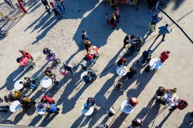 Bükreş, Romanya - 28 Kasım 2021: Güneşli bir sonbahar gününde Moghioros olarak bilinen Drumul Taberei Park 'taki (Parcul Drumul Taberei) Noel Pazarı' nda yemek yiyen insanların yukarıdan görüntüsü