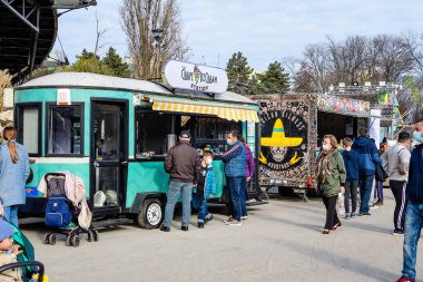 Bükreş, Romanya - 28 Kasım 2021: Güneşli bir günde, Davul Taberei Parkı 'nda (Parcul Drumul Taberei) geleneksel içki, yiyecek ve tatlılarla dolu renkli bir minibüs.