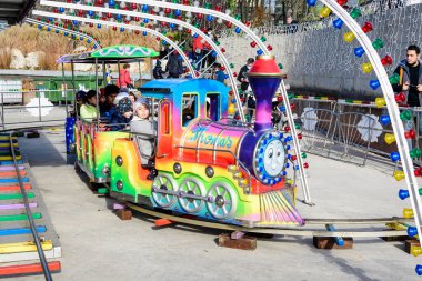 Bükreş, Romanya - 28 Kasım 2021: Güneşli bir sonbahar gününde, Drumul Taberei Park 'taki (Parcul Drumul Taberei) Noel Pazarı' nda (Parcul Drumul Taberei) oyuncaklarla eğitim gören renkli çocuklar