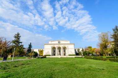 Bucharest, Romania, 6 November 2021 - Romanian National Opera building in a sunny autumn day with white clouds and clear blue sky