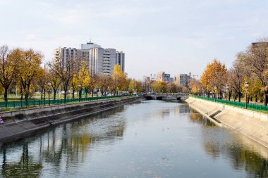 Bucharest, Romania, 6 November 2021: Modern buildings and offices near Dambovita river and cloudy blue sky in the center of the city, in a cloudy autumn day