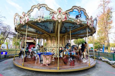 Bucharest, Romania, 13 November 2021: Colourful children colorful carousel with mixed plastic and metallic toys and materials in Parcul Tei (Linden Park) in a sunny autumn day