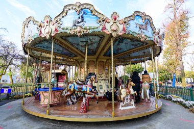 Bucharest, Romania, 13 November 2021: Colourful children colorful carousel with mixed plastic and metallic toys and materials in Parcul Tei (Linden Park) in a sunny autumn day