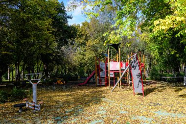 Romanya 'nın Bükreş kentindeki Carol Park' ta güneşli bir yaz gününde karışık plastik ve metalik oyuncaklar ve malzemelerle dolu renkli çocuk parkı