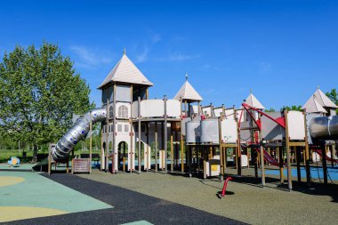 Romanya 'nın Bükreş kentindeki Izvor Park' ta (Parcul Izvor) güneşli bir yaz gününde karışık plastik ve metalik oyuncaklar ve malzemelerle dolu renkli çocuk parkı