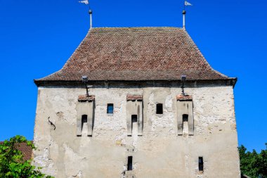 Romanya 'nın Transilvanya (Transilvanya) bölgesindeki Sighisoara kalesinin tarihi merkezinde güneşli bir yaz gününde büyük beyaz boyalı taş kule