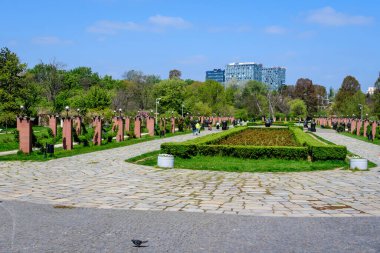 Bükreş, Romanya - 30 Nisan 2021: Ana ara sokağa ve güneşli bir bahar gününde Kral I. Michael Park 'ta (Herastrau) çok sayıda büyük yeşil ağaca sahip manzara
