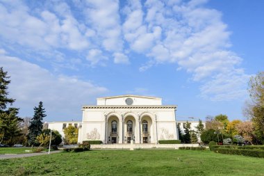 Bucharest, Romania, 6 November 2021 - Romanian National Opera building in a sunny autumn day with white clouds and clear blue sky