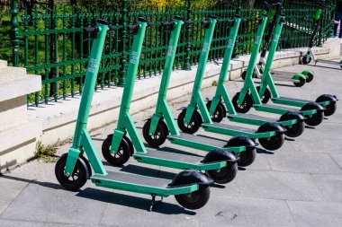 Bükreş, Romanya, 10 Nisan 2021: Şehir merkezinde vatandaşlar ve turistler için özel mobil uygulama kullanılarak kiralık elektrikli scooterlar