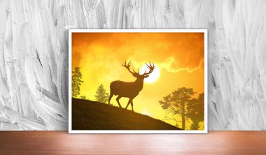 Ahşap arka planda geyik ve çam ağacı olan bir Noel kartı.